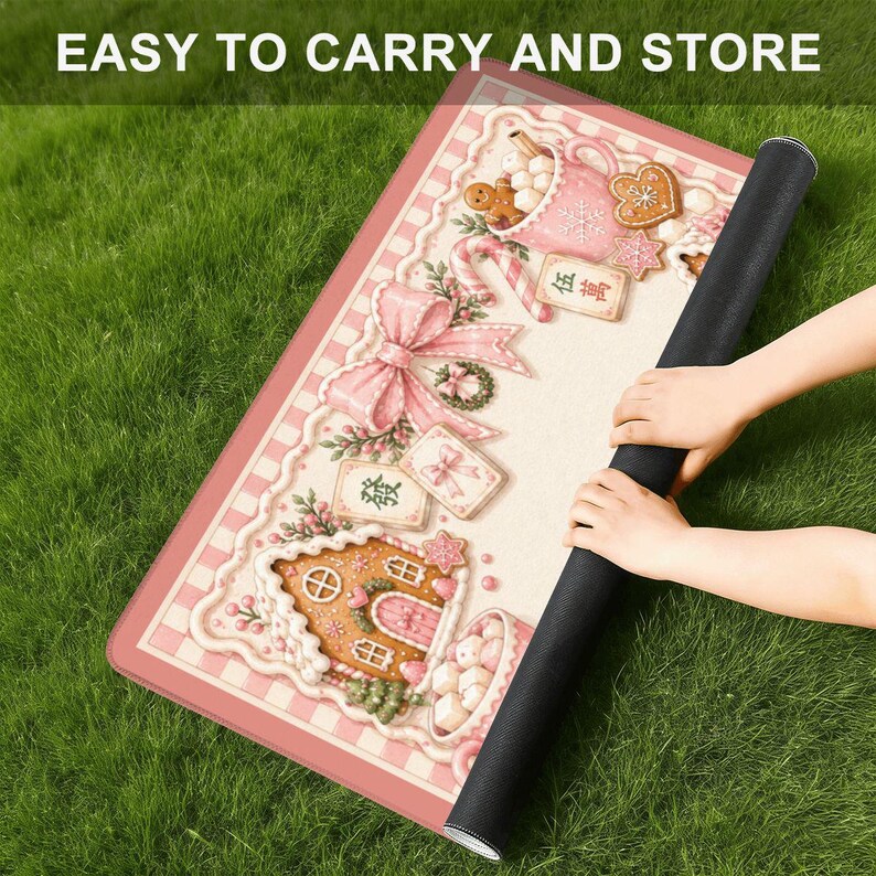 May include: A rolled-up black mat with a pink and white patterned design featuring gingerbread houses, bows, and cookies. The text "EASY TO CARRY AND STORE" is at the top. The mat is on a green grassy surface.