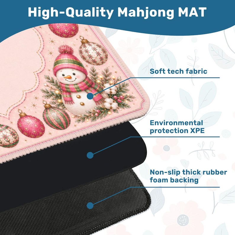 May include: A Mahjong mat featuring a pink background with a snowman, Christmas ornaments, and greenery. The mat is composed of three layers: a soft tech fabric top, an environmental protection XPE middle layer, and a non-slip thick rubber foam backing.