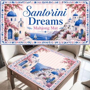 Pode incluir: Um tapete de mahjong retangular com uma cena impressa de Santorini com edif&iacute;cios brancos, c&uacute;pulas azuis e flores cor-de-rosa. O texto "Santorini Dreams Mahjong Mat" est&aacute; centrado no topo. O tapete tem uma borda floral decorativa em azul e rosa.