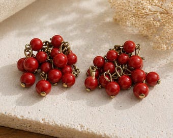 Pendientes de clip vintage con cuentas rojas en forma de racimo y acabado dorado.