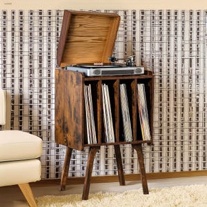 May include: A brown wooden record player stand with a built-in record storage shelf. The stand has a retro design with four legs and a hinged lid that opens to reveal a turntable. The stand is filled with vinyl records.