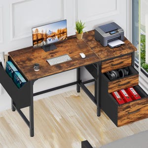 May include: A brown wooden desk with black metal legs and a black file cabinet with three drawers. The desk has a computer monitor, keyboard, mouse, and a printer on it. The file cabinet has folders and headphones in the drawers.