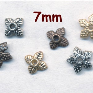 May include: Five metal flower-shaped bead caps in different finishes: silver, gold, antique silver, antique brass, and antique copper. Each cap measures 7 mm in diameter.