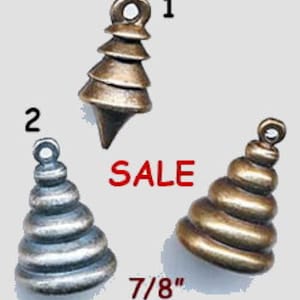 May include: Three metal Christmas tree charms in different finishes: gold, silver, and bronze. Each charm is 7/8 inch tall and has a layered, tiered design.