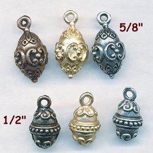 May include: Six ornate metal pendant charms in three different finishes: antique brass, silver, and gold. The charms are shaped like ovals with intricate designs and are available in two sizes: 1/2 inch and 5/8 inch.