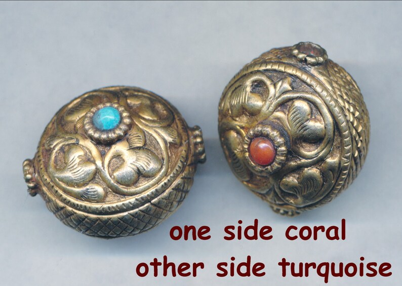 Puede incluir: Dos cuentas redondas de color dorado con intrincados dise&ntilde;os florales. Una cuenta tiene una piedra turquesa en un lado y una piedra de coral en el otro.