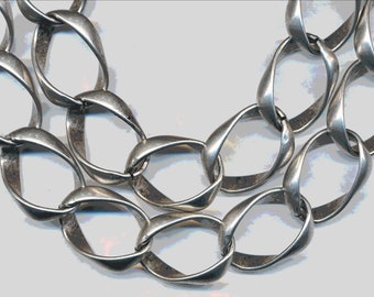 May include: A silver chain necklace with large, oval-shaped links. The links are twisted and have a slightly textured finish.