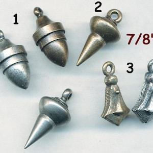 May include: Five metal pendants, each with a different design. The pendants are 7/8 inches in size and are made of silver and brass. The pendants are numbered 1 through 5.