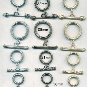 May include: Assortment of silver and gold toggle clasps in various sizes. The clasps are 18mm, 21mm, 22mm, and 28mm in diameter.