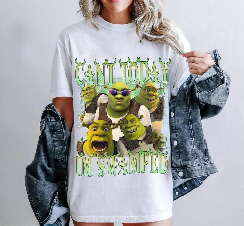 May include: White t-shirt with a green Shrek character graphic and the text "CANT TODAY IM SWAMPED".