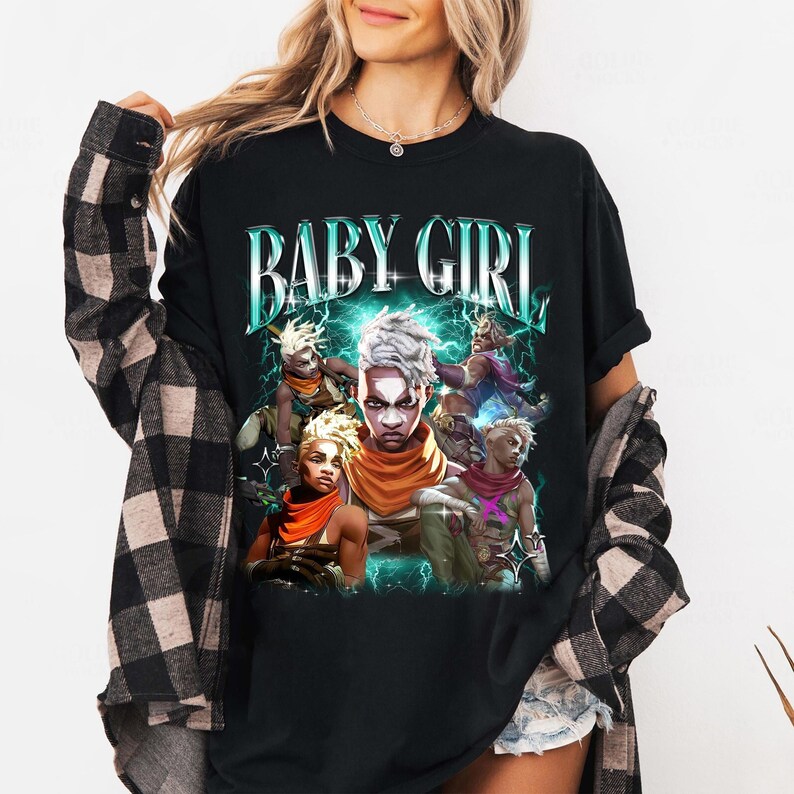 May include: Black t-shirt with a graphic print of a group of cartoon characters with the text "BABY GIRL" in a retro style.