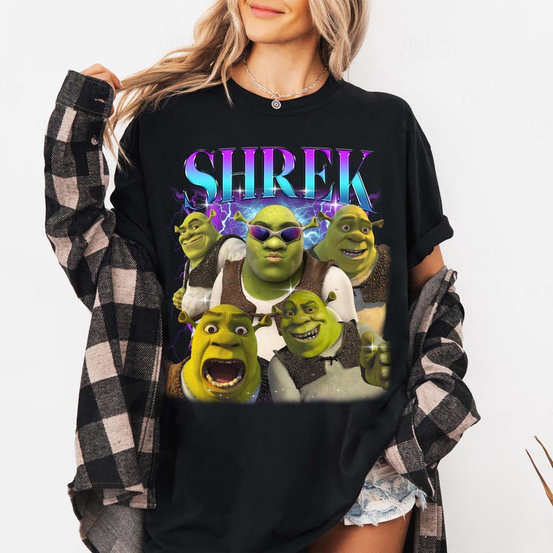 May include: Black t-shirt with a graphic print of Shrek and other characters from the Shrek movie franchise. The text "SHREK" is printed in a colorful, retro font.