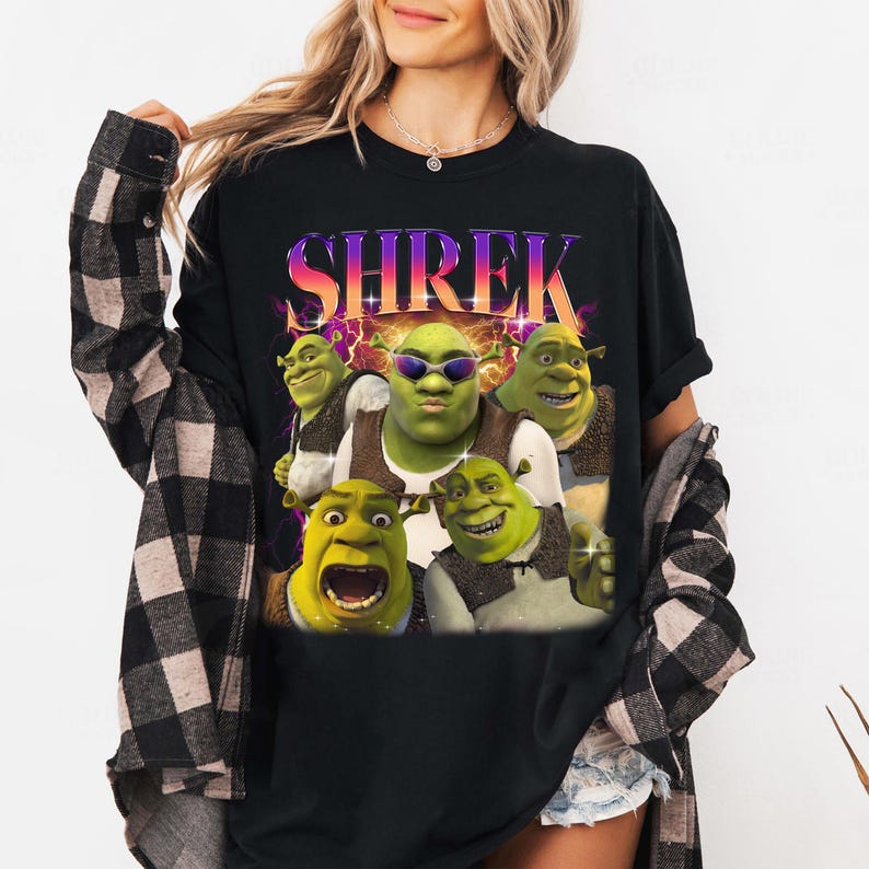 May include: Black t-shirt with a graphic print of Shrek and other ogre characters. The text "SHREK" is printed in a colorful, retro-style font.