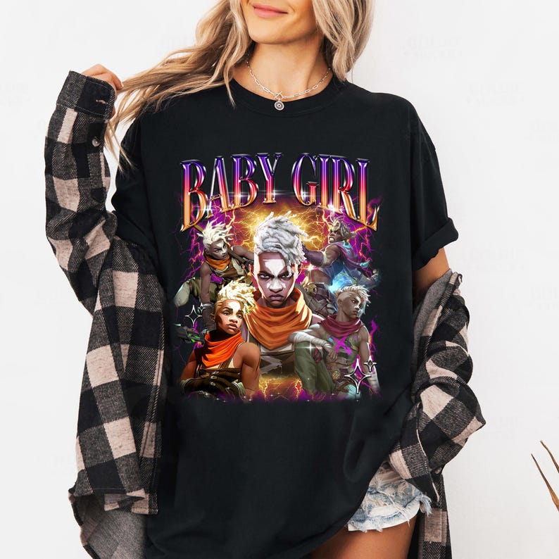 May include: Black t-shirt with a graphic print of a group of characters from a video game. The text "BABY GIRL" is printed in a retro style font above the characters.
