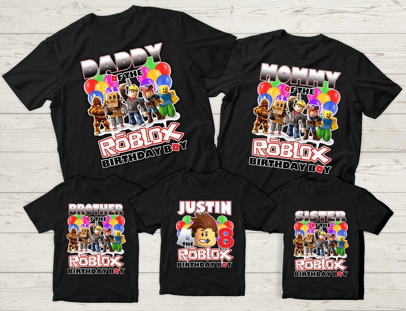 May include: Set of five black t-shirts with a Roblox theme. The shirts feature different text, including "Daddy of the Roblox Birthday Boy", "Mommy of the Roblox Birthday Boy", "Brother of the Roblox Birthday Boy", "Sister of the Roblox Birthday Boy", and "Justin of the Roblox Birthday Boy".