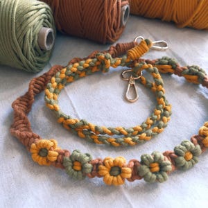 Pu&ograve; includere: Un cordoncino intrecciato verde, marrone e giallo con una chiusura in metallo e dettagli floreali. Il cordoncino &egrave; in cotone e misura circa 76 cm di lunghezza.