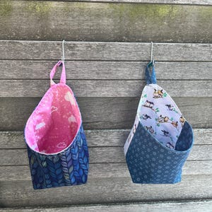 Gebruiksvoorwerp om op te hangen in de keuken, badkamer, commode etc. van stof of met softshell. Lus met knoop zodat hij niet zomaar aan haakjes blijft hangen.