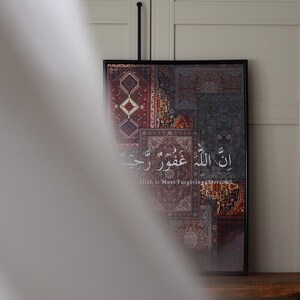 Może przedstawiać: Oprawiona grafika z patchworkowym wzorem wzorzystych dywan&oacute;w w odcieniach czerwieni, błękitu i beżu. Grafika zawiera arabską kaligrafię i angielskie tłumaczenie "Allah is Most Forgiving, Merciful."