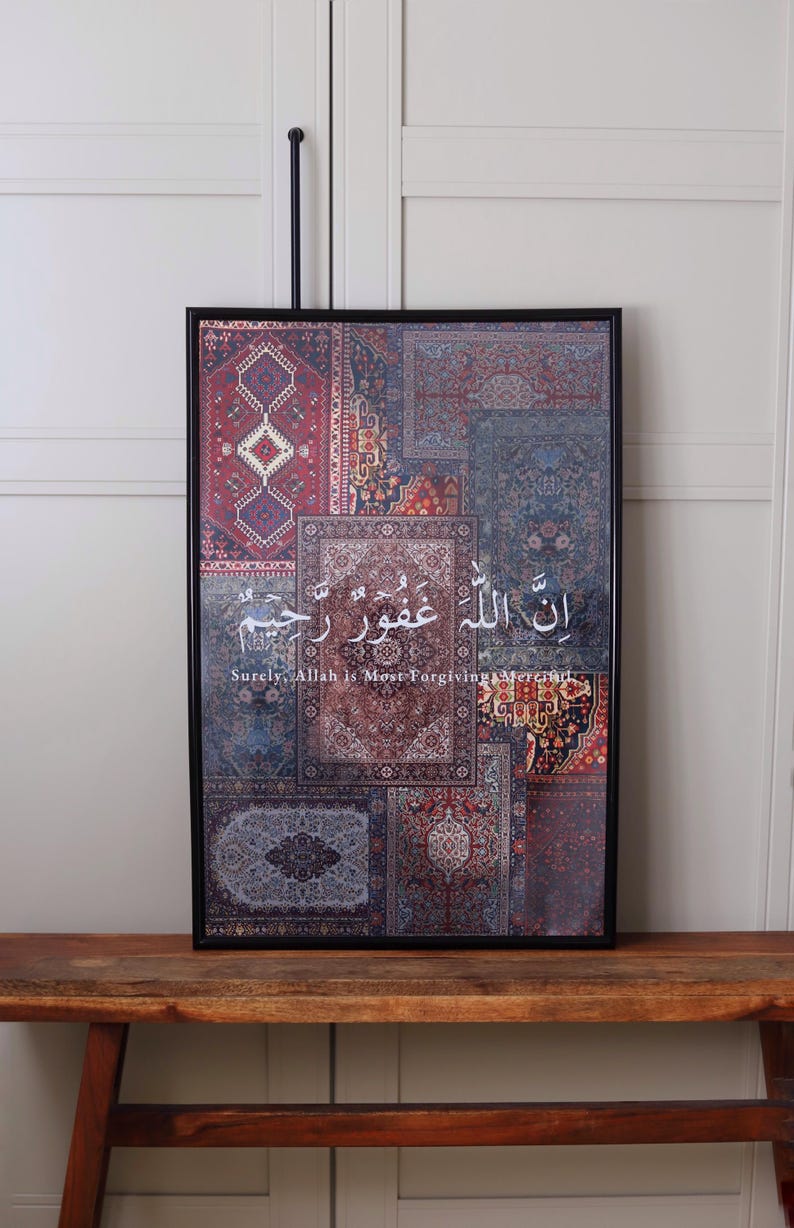 Może przedstawiać: Oprawiony wydruk artystyczny z patchworkowym wzorem wzorzystych dywan&oacute;w w odcieniach czerwieni, błękitu i kremu. Grafika zawiera arabską kaligrafię z angielskim tłumaczeniem "Surely, Allah is Most Forgiving, Merciful."