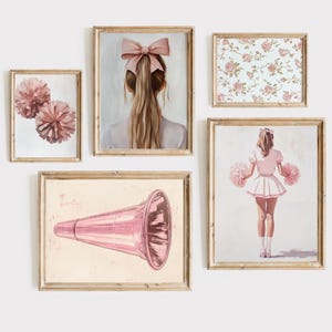 May include: A set of five framed prints featuring pink and white illustrations. The prints include a girl with a pink bow in her hair, a floral pattern, a cheerleader with pom-poms, and a pink megaphone.