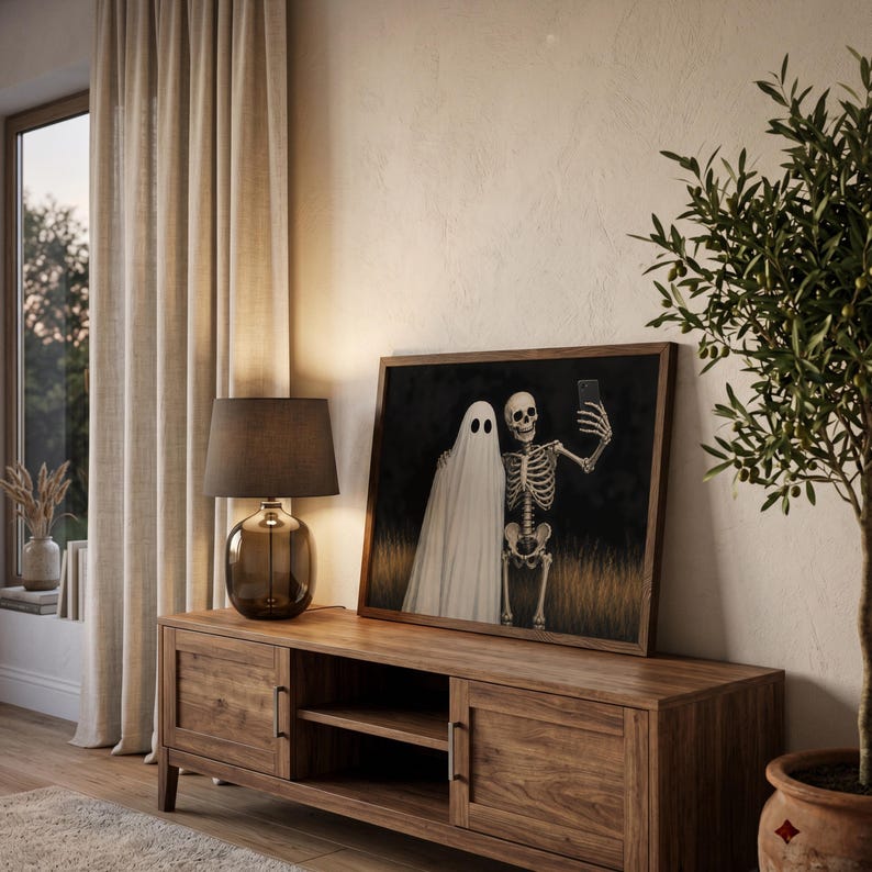 Peut inclure: Une impression d'art mural rectangulaire encadr&eacute;e repr&eacute;sentant un fant&ocirc;me blanc et un squelette humain c&ocirc;te &agrave; c&ocirc;te dans un champ d'herbes hautes. Le squelette tient un smartphone pour prendre un selfie avec le fant&ocirc;me sur un fond sombre.