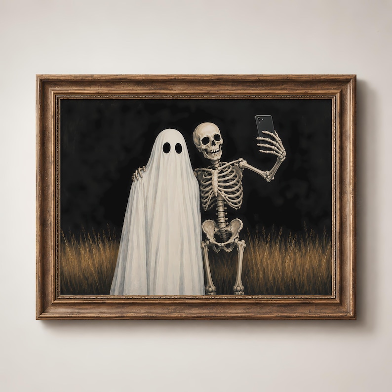 Peut inclure: Une impression d'art encadr&eacute;e repr&eacute;sentant un fant&ocirc;me blanc et un squelette humain c&ocirc;te &agrave; c&ocirc;te dans un champ d'herbes hautes. Le squelette tient un smartphone noir pour prendre un selfie avec le fant&ocirc;me, sur un fond sombre.