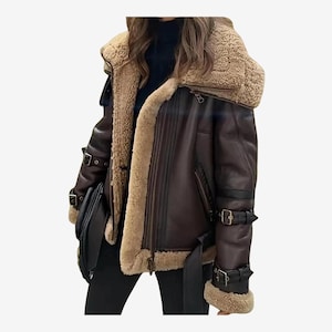 May include: A brown leather jacket with a shearling lining and collar. The jacket features a zip closure, multiple pockets, and adjustable straps with buckles. The sleeves have shearling cuffs, and a belt cinches the waist. A stylish outerwear piece.