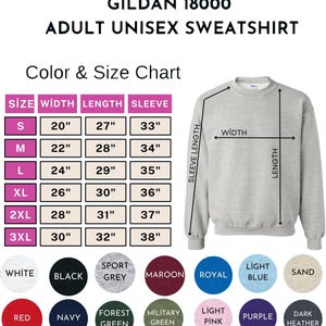 May include: A light grey Gildan 18000 adult unisex sweatshirt. The image includes a colour and size chart with measurements in inches. Available colours include white, black, sport grey, maroon, royal blue, light blue, sand, red, navy, forest green, military green, light pink, purple, and dark heather.