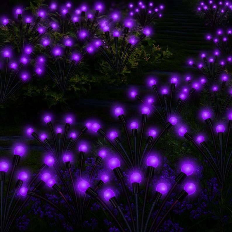 May include: A nighttime garden scene features multiple clusters of solar-powered lights. Each cluster has a black stem with multiple thin branches, each topped with a glowing purple orb. The lights are arranged among dark green foliage and purple flowers.