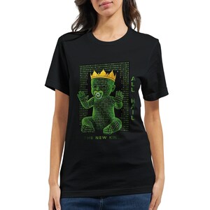 May include: Black t-shirt featuring a green graphic of a baby made of binary code wearing a gold crown and pacifier. The text "ALL HAIL" is on the right side, and "THE NEW KING" is at the bottom of the graphic.