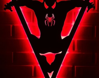 May include: A black silhouette of Spider-Man in a triangle shape with red LED lights around the edges. The silhouette is against a red brick wall.