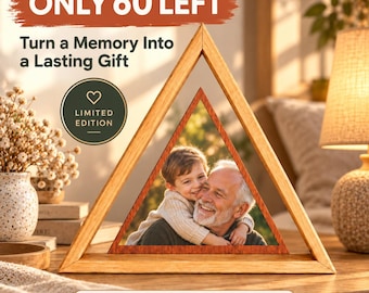 Op de afbeelding: Een driehoekig houten frame met een metalen print van een kind dat een oudere man omhelst. Het frame bevat de tekst: ONLY 60 LEFT, Turn a Memory Into a Lasting Gift, LIMITED EDITION en Personalized • Premium Metal Print.