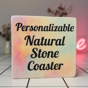 Puede incluir: Un posavasos cuadrado de piedra natural con un diseño similar a la acuarela en tonos de rosa, amarillo y azul. El texto "Posavasos de piedra natural personalizable" está impreso en negro en el posavasos.