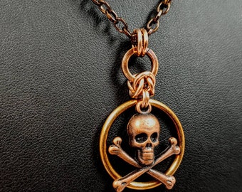 Colgante de malla metálica con calavera y tibias cruzadas de bronce / Medallón pirata