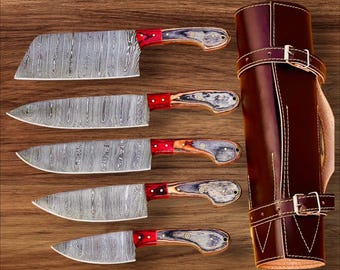 May include: Set of five kitchen knives with Damascus steel blades and wooden handles. The knives are arranged in a row on a wooden surface, with a brown leather roll for storage.