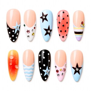 Op de afbeelding: Tien amandelvormige kunstnageltips met diverse ontwerpen, waaronder zwart-witte stippen, lichtblauw met donkere sterren, koraal met zwarte stippen, horizontale strepen, oranje gradiënten met doorzichtige kralen en kleurrijke strass-steentjes.