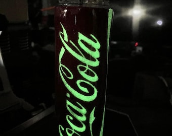 Vaso de refresco de cola con brillantina que brilla en la oscuridad