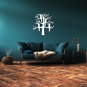 May include: A white metal tree wall art decor is mounted on a teal wall above a teal sofa with a brown wooden frame. The room has a wooden floor with a herringbone pattern. A decorative vase and side table are also visible.