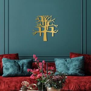 May include: A gold-colored metal wall art piece in the shape of a stylized tree with birds. The artwork is mounted on a teal wall above a red velvet sofa with teal pillows. The room is decorated with flowers.