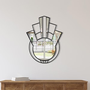 Könnte beinhalten: Ein runder Spiegel mit geometrischem Design, gerahmt in schwarzem Metall. Der Spiegel hat ein fächerförmiges Design mit einem Kreis um die Außenseite.