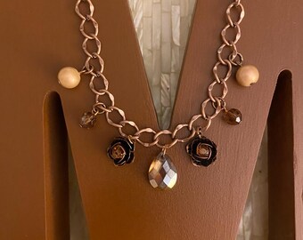 Elegant bronze/copper tone graduated charm necklace designed with 7 vintage charms