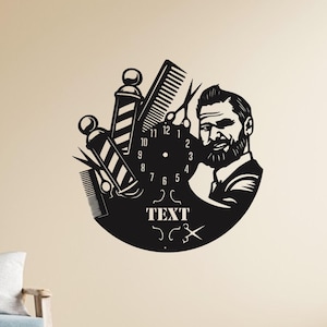 Puede incluir: Reloj de pared negro con diseño de barbería. Presenta un poste de barbero, tijeras, peines y la cara de un hombre sonriente. La esfera del reloj incluye números y la palabra "TEXT". Un artículo decorativo para una barbería.