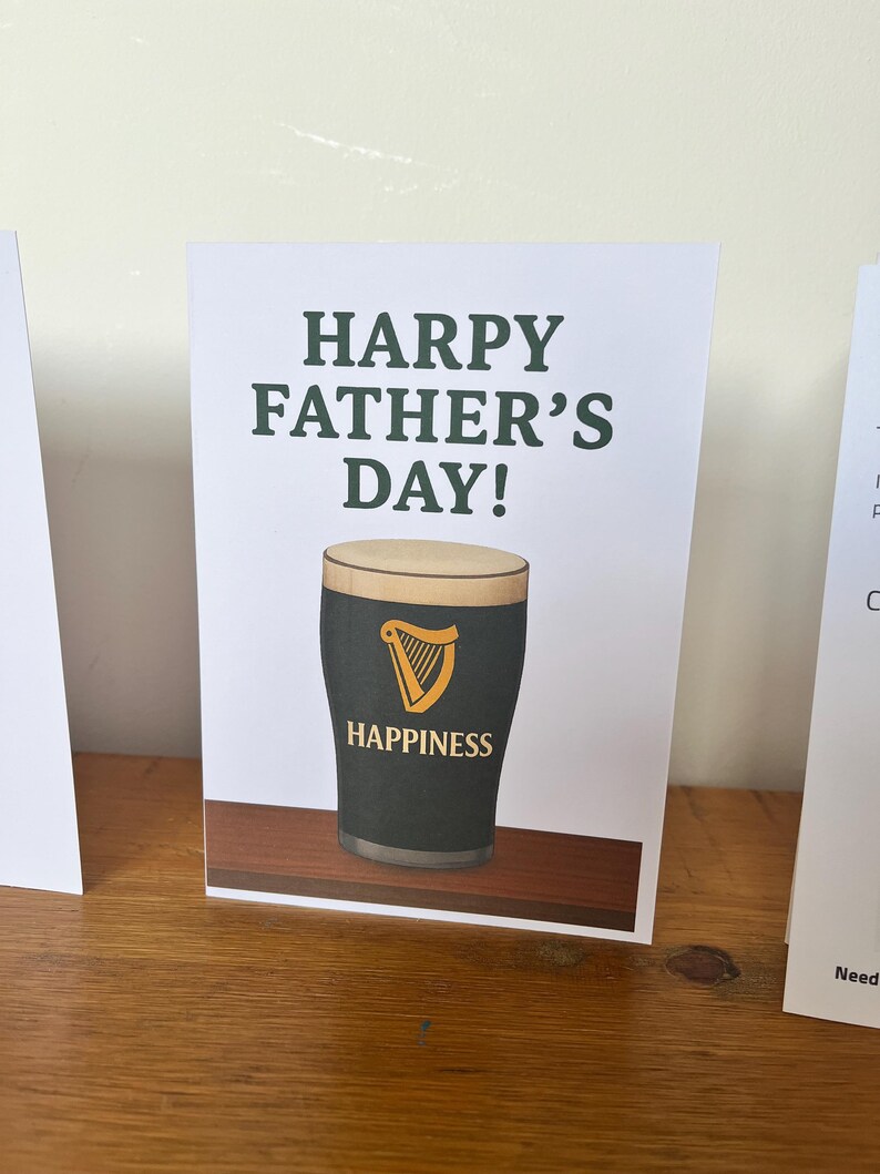 May include: A white ceramic mug with a black handle and the text "But First, Coffee" in a bold, black font. The mug is filled with a dark liquid, likely coffee, and sits on a light-colored surface.