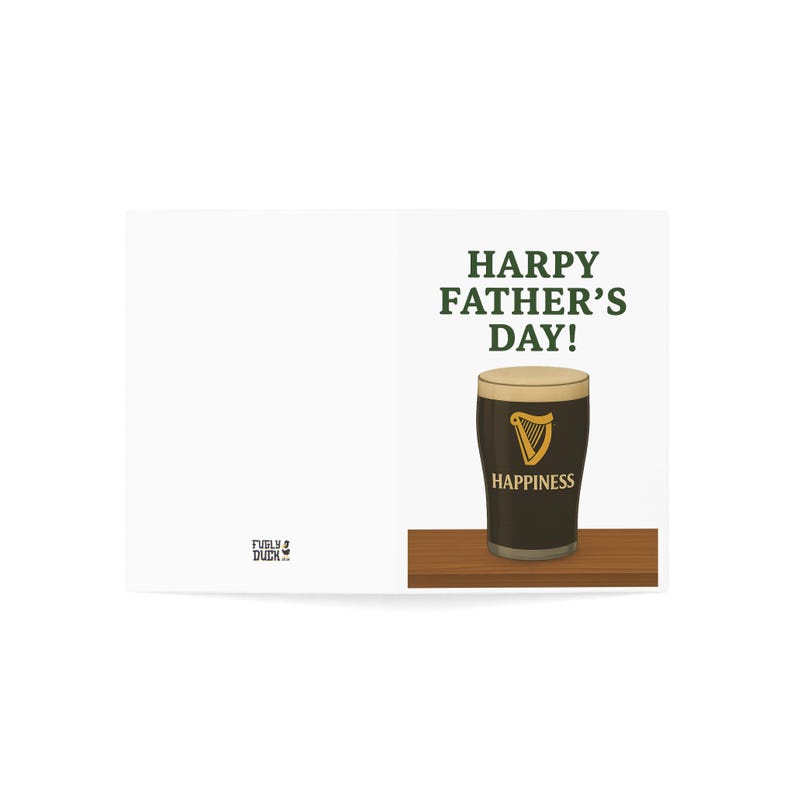 May include: A Father's Day greeting card featuring a pint of stout with a creamy head. The card reads "HARPY FATHER'S DAY!" above the pint and "HAPPINESS" below. The pint glass has a gold harp logo.