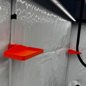 Könnte beinhalten: Zwei leuchtend orangefarbene Kunststoffschalen, die an der Wand eines Grow-Zeltes befestigt sind. Die Schalen sind so konzipiert, dass sie kleine Gegenstände wie Werkzeuge oder Zubehör aufnehmen können.