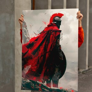 May include: A digital art print of a Spartan warrior in full armor, with a red cape billowing in the wind. The warrior is standing on a rocky terrain, with a shield and helmet. The artwork has a dramatic, painterly style.