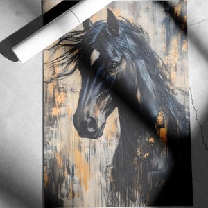 May include: An artistic print of a black horse's head with flowing mane. The artwork features a textured background with gold and neutral tones. A rolled-up white poster is placed on top of the print.