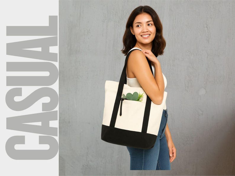 May include: A canvas tote bag with a black base and straps, and a cream-colored body. The bag has a front pocket with a black zipper and a green plant inside. The word "CASUAL" is printed in large gray letters on the left.