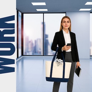 May include: A woman in a black blazer and gray pants holds a smartphone and a black notebook. She carries a cream-colored tote bag with navy blue accents and handles. The word "WORK" is displayed in large, navy blue letters on the left.