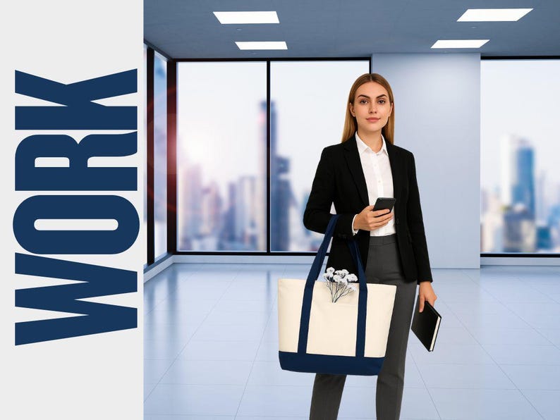 May include: A woman in a black blazer and gray pants holds a smartphone and a black notebook. She carries a cream-colored tote bag with navy blue accents and handles. The word "WORK" is displayed in large, navy blue letters on the left.